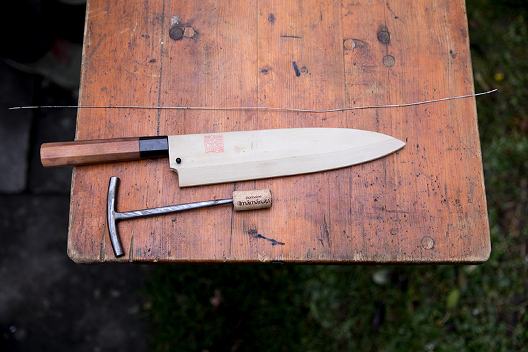 Draht, Messer und Spieß, die für die Ike Jime Methode benötigt werden, liegen nebeneinander auf einem Tisch