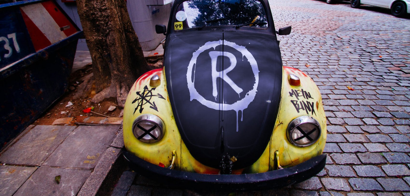 Alter VW Käfer mit Graffiti und aufgesprühtem RIEGG-Logo