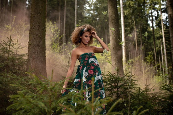 Weibliches Model in grünes Handtuch gewickelt steht im Wald