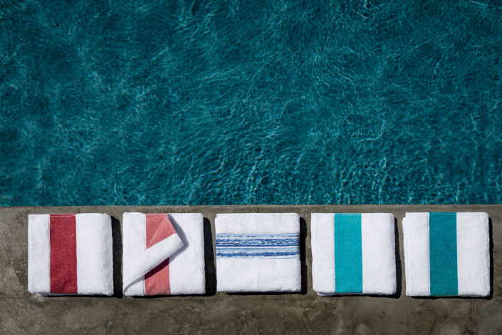 Verschieden farbig gestreifte Handtücher von Feiler am Pool